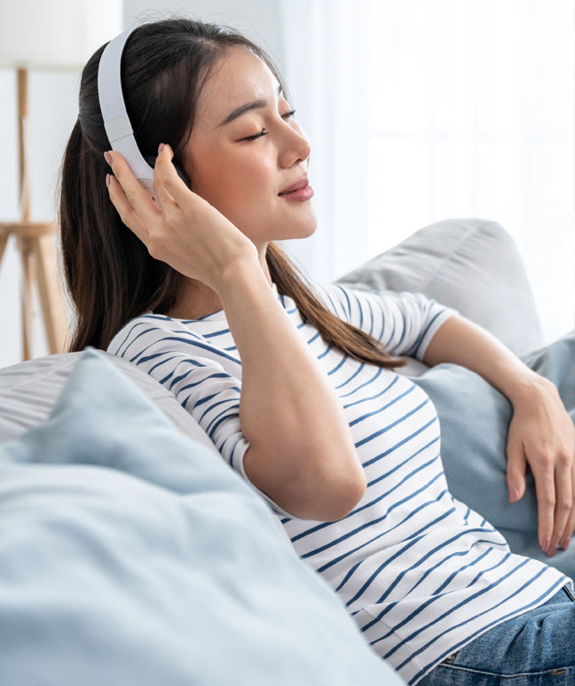 Woman Relaxing With Music On Her Couch